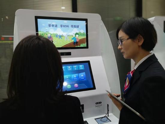工作人員指導(dǎo)市民使用自助服務(wù)機。浙江省人社廳供圖